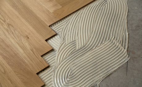 Construction in a renovated room installation of parquet. Pad applied with glue for parquet